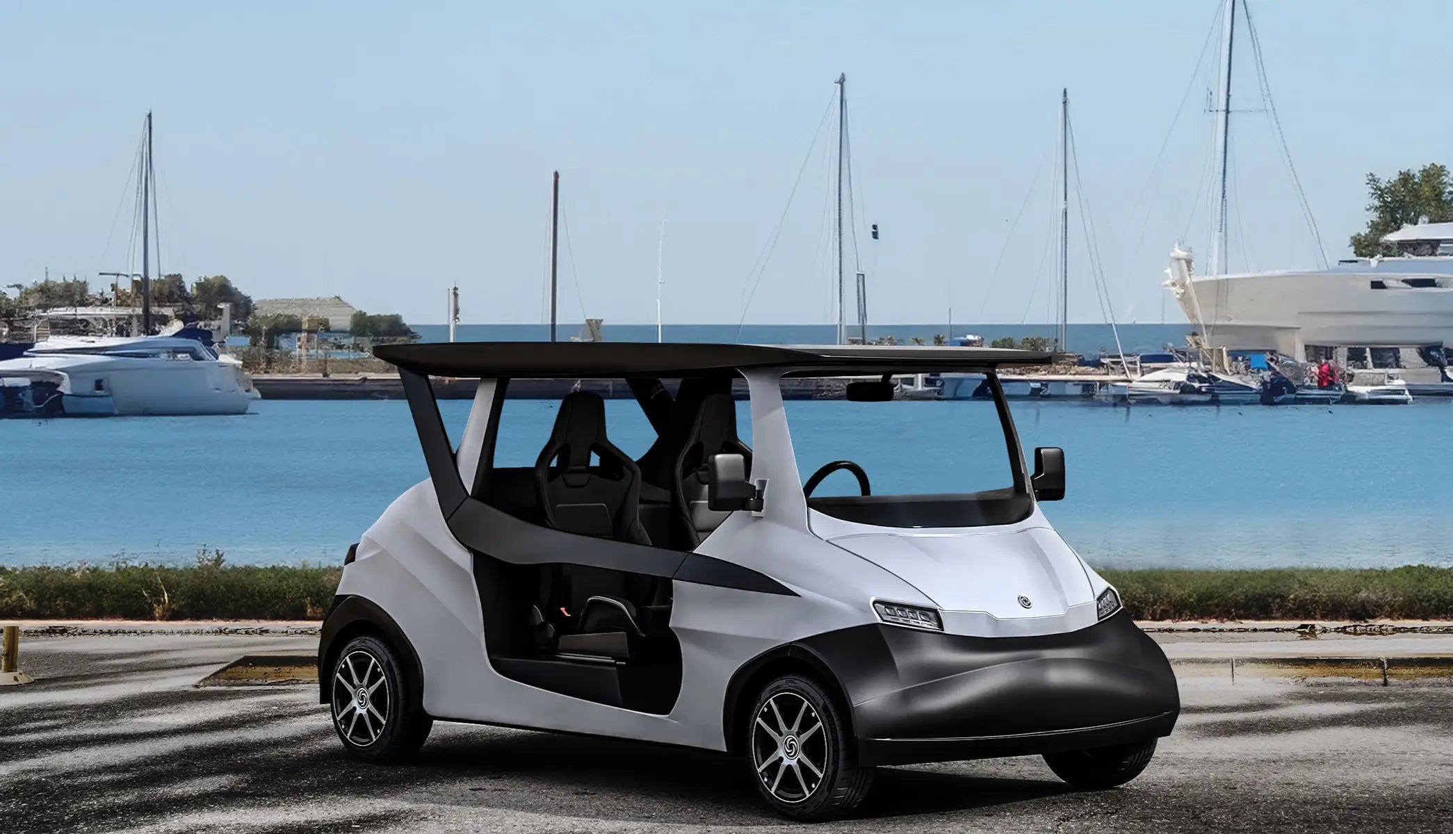 White INTI Neighborhood Solar Car parked near a marina, with sailboats and yachts docked in calm blue waters under a clear sky.